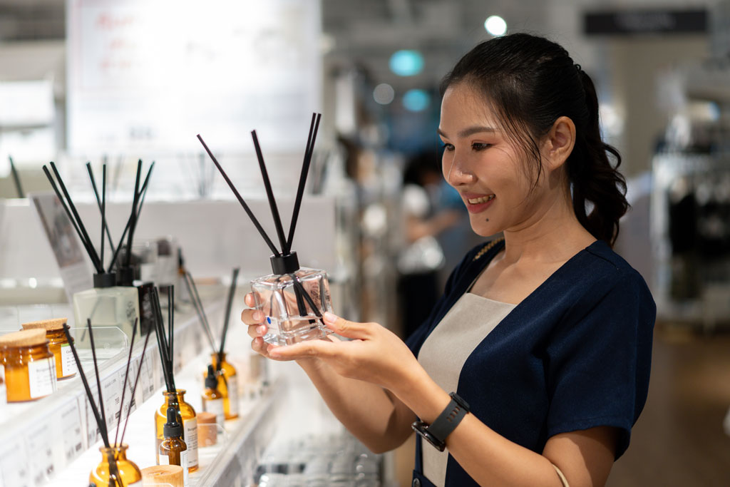 A woman looking at scent options in a store.